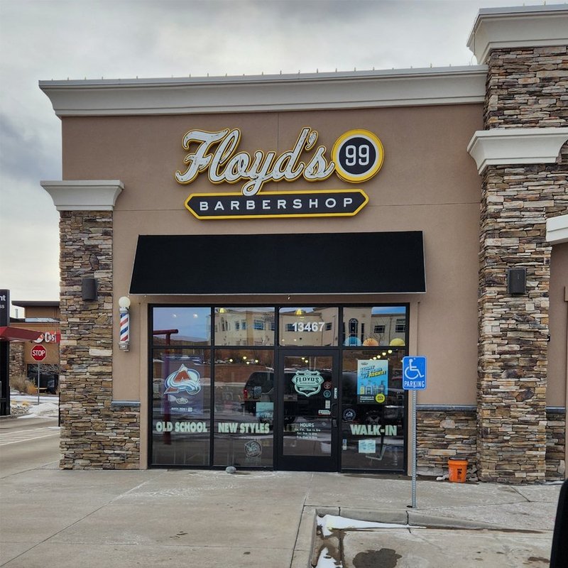 Completed Floyd's 99 Barbershop storefront with black awning and stacked stone columns