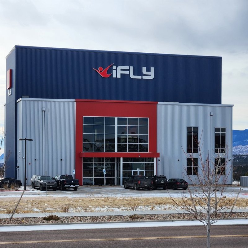 Completed iFLY indoor skydiving facility exterior with navy and red metal panel walls