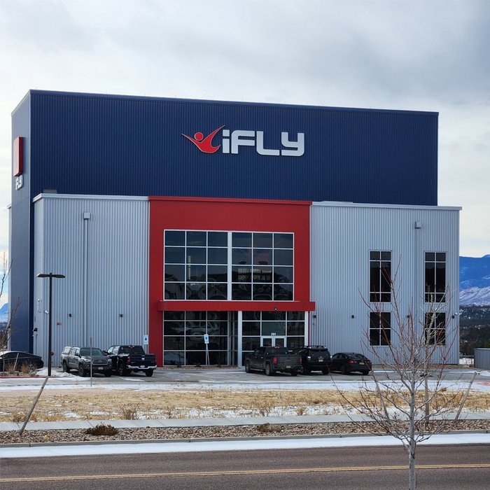 Completed iFLY indoor skydiving facility exterior with navy and red metal panel walls