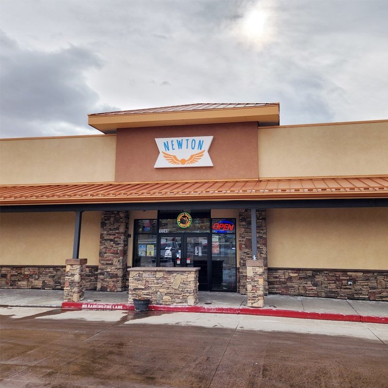 Completed Newton storefront exterior with stone accents and a standing seam metal awning