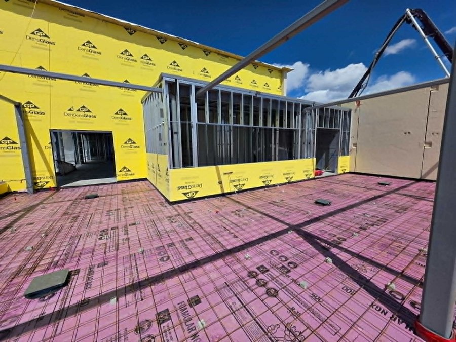 Rooftop metal stud framing with yellow DensGlass sheathing and rigid insulation board
